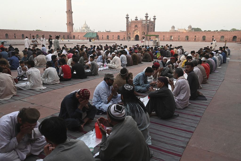 Umat Islam berdoa saat mereka menunggu untuk berbuka puasa di Masjid Badshahi yang bersejarah pada bulan suci Ramadhan di Lahore, Pakistan, Senin (4/4/2022).