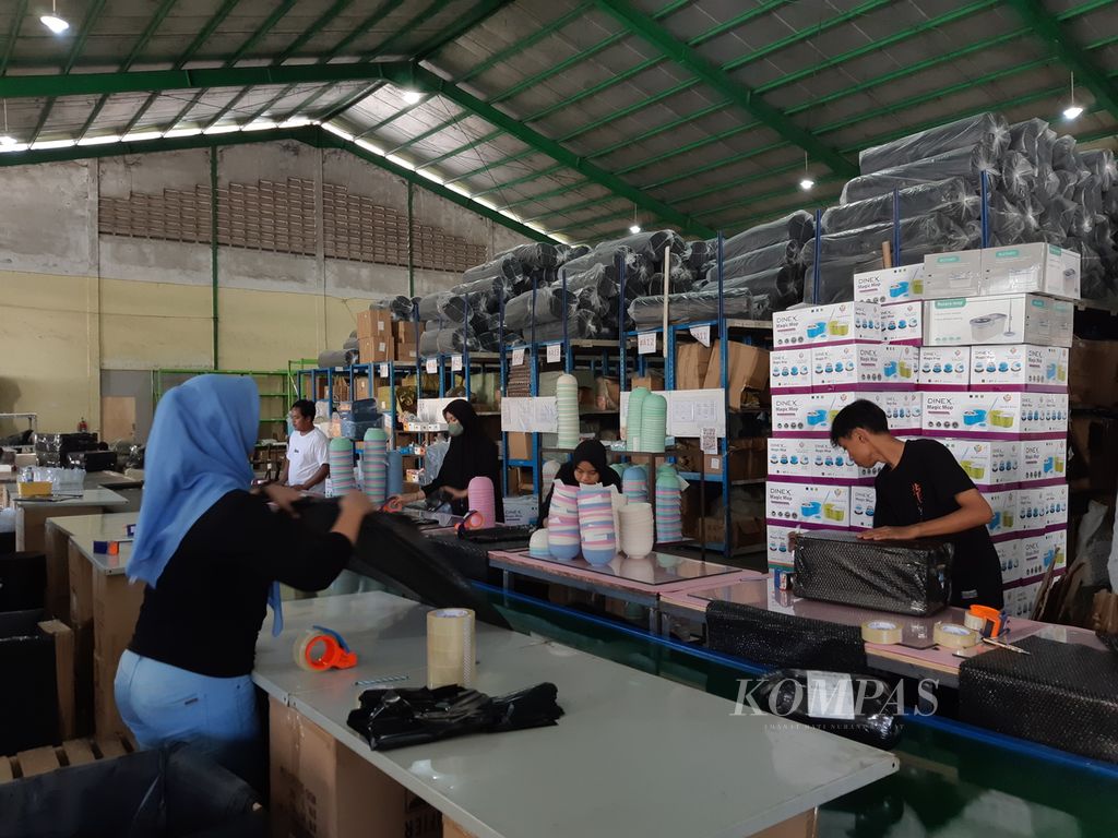 Para karyawan salah satu <i>seller </i>produk sibuk mengemas sejumlah produk yang dibeli konsumen secara daring, Selasa (10/10/2023), di Jalan Industri, Kecamatan Cikupa, Kabupaten Tangerang, Banten. Penjualan di  tempat ini turun drastis sejak Tiktok Shop dilarang pemerintah.