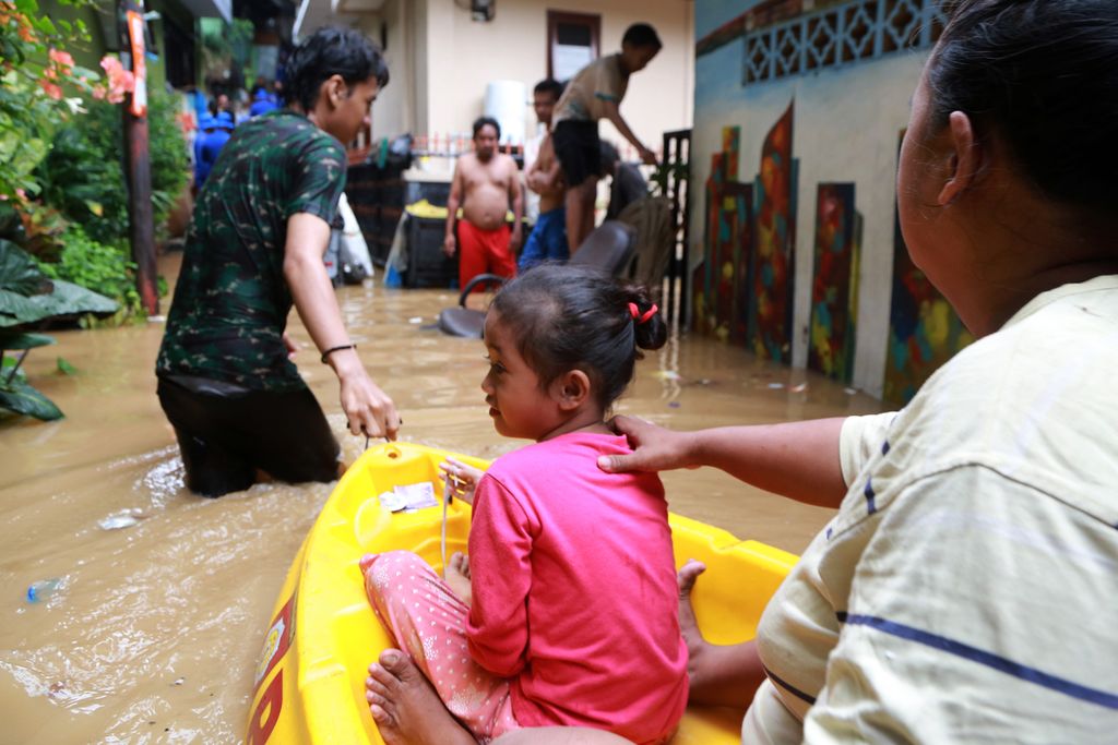 Warga bergotong royong untuk mengevakuasi sesama warga di tempat yang lebih aman dari banjir, Kebon Pala, Kampung Melayu, Jakarta Timur, Senin (10/10/2022). 