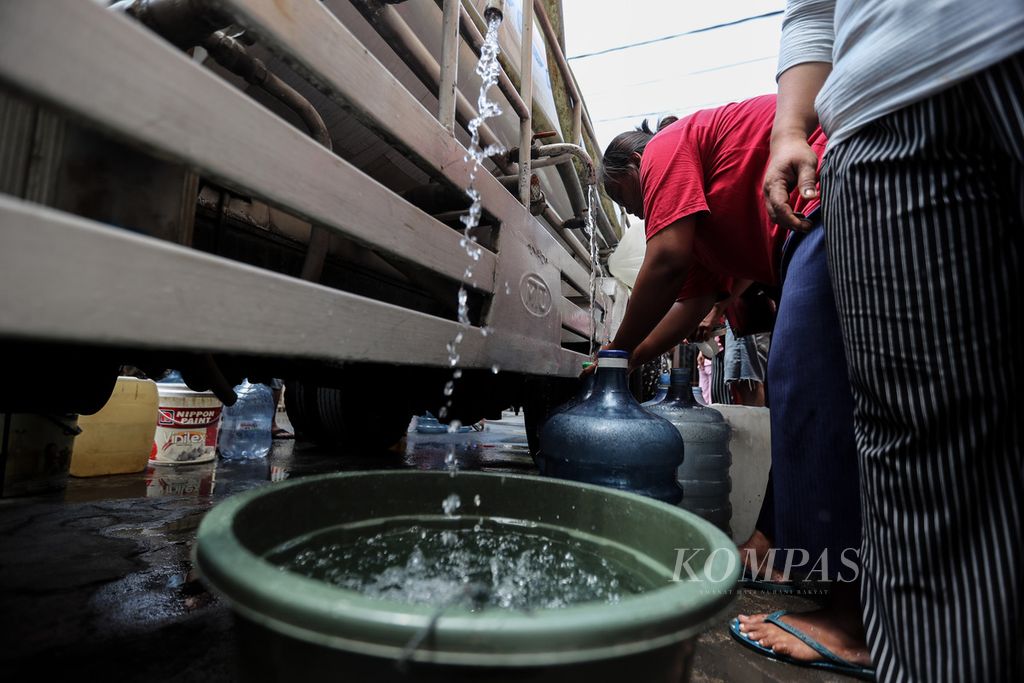Air bantuan mengalir memenuhi wadah penampung air milik warga RW 011 Kecamatan Kalideres, Jakarta Barat, Kamis (14/9/2023).