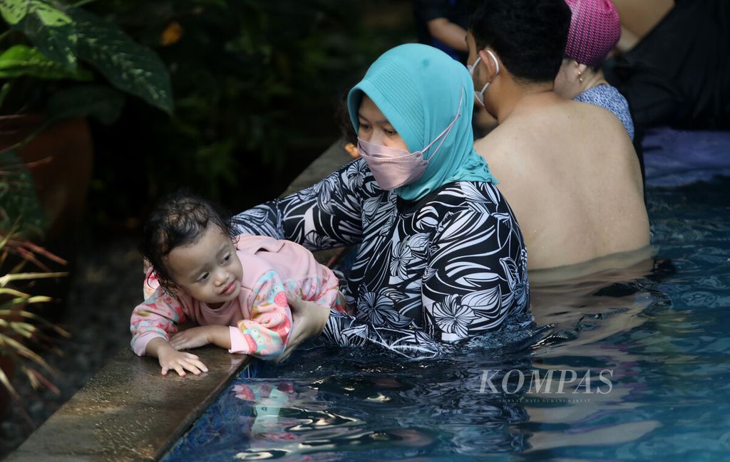 Seorang ibu memberikan pengenalan kolam kepada anaknya sebelum mulai berlatih renang di kolam yang dikelola Splish Splash Indonesia di kawasan Cempaka Putih, Jakarta, akhir Juli 2022.