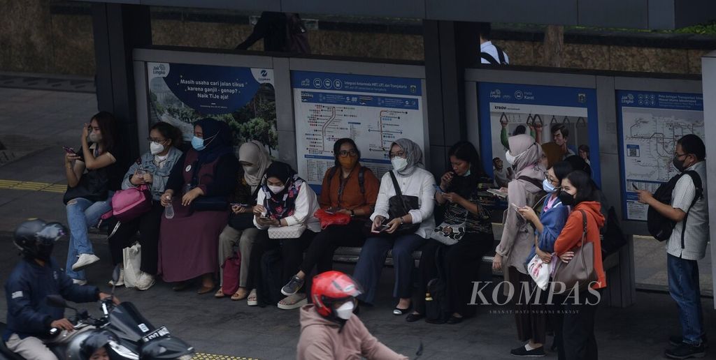 Passengers wait for the Transjakarta bus at the Karet stop, Sudirman area, Jakarta, during work hours, Monday (5/12/2022). Indonesia's economic growth in 2023 is projected to be above 5 percent. However, high global economic uncertainty has the potential to increase pressure on the domestic economy.
