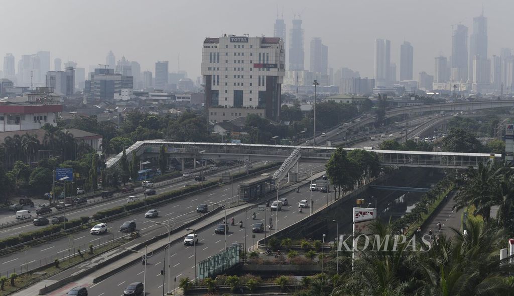 Kendaraan melintas di Jalan S Parman, Jakarta, dengan latar belakang gedung-gedung bertingkat, Selasa (8/6/2021). 