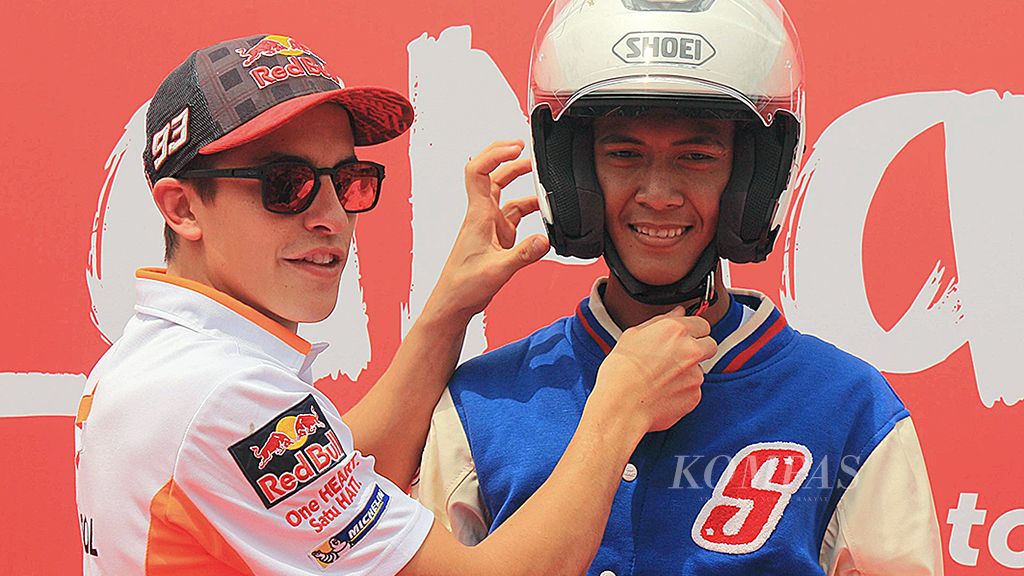 Juara Dunia MotoGP 2016, Marc Marquez, Selasa (17/10), memasangkan helm kepada M Bustomi, siswa kelas 2 SMKN 53 Jakarta, yang mengikuti program kampanye keselamatan berkendara yang diselenggarakan Astra Honda Motor di Serpong, Tangerang Selatan. Marquez pun memotivasi para peserta untuk selalu mengutamakan keselamatan berkendara.