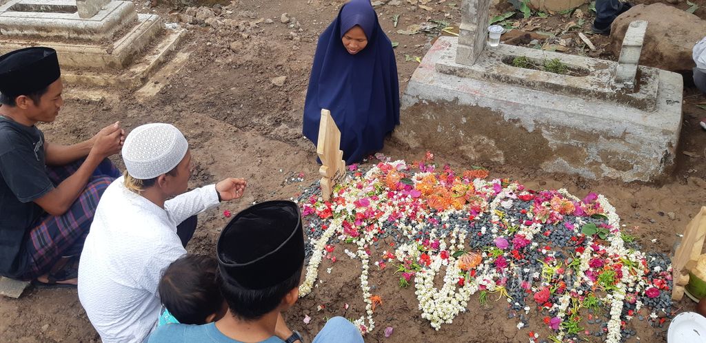 Keluarga berdoa di makam Rasni, korban pembunuhan, di Desa Cangkoak, Kecamatan Dukupuntang, Kabupaten Cirebon, Jawa Barat, Senin (27/11/2023). Korban diduga menjadi korban pembunuhan oleh mantan suami sirinya.