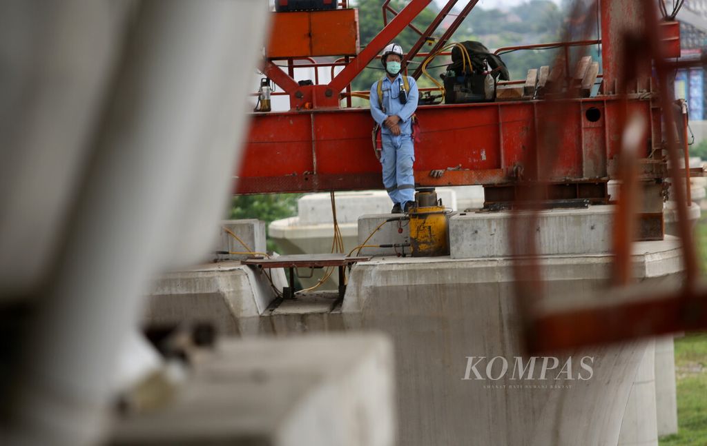 Pekerja bersiap saat proses pemasangan gelagar untuk jalur layang Kereta Cepat Indonesia China (KCIC) saat pembangunan proyek KCIC di kawasan Curug, perbatasan Jakarta Timur dan Bekasi, Jawa Barat, Selasa (14/6/2022). 