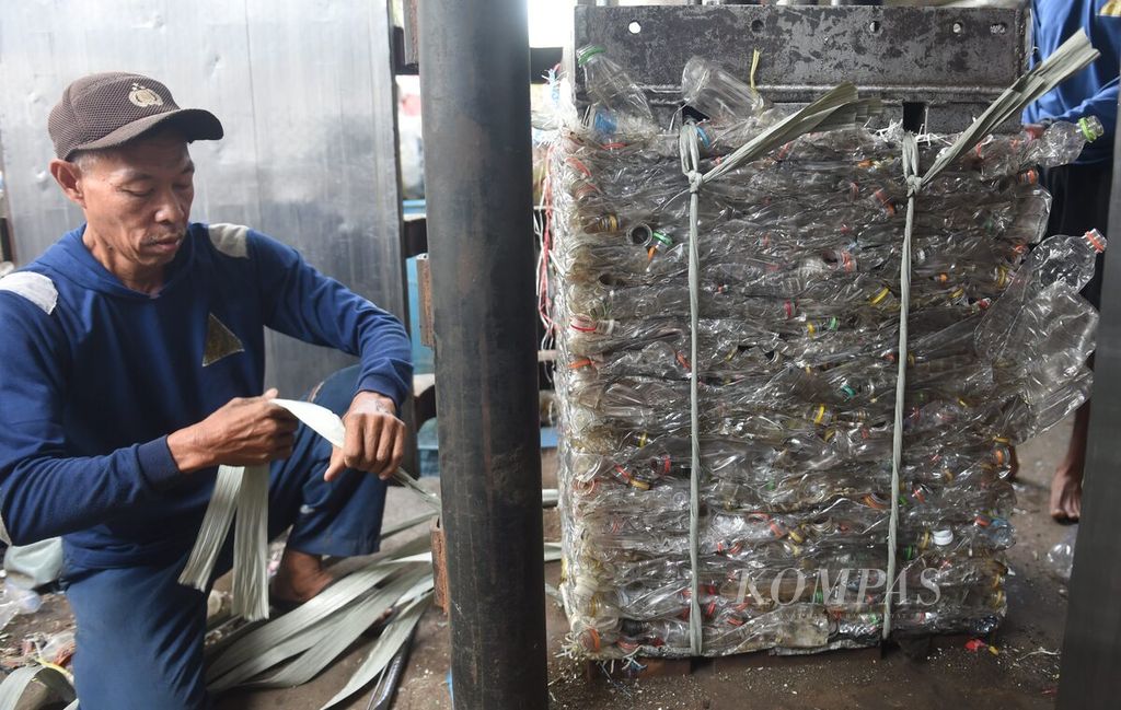 Pekerja mengeluarkan karung berisi botol plastik dari mesin pengepresan di pengepul sampah plastik CV Alvin Jaya di Kecamatan Sukodono, Kabupaten Sidoarjo, Jawa Timur, Jumat (13/1/2023). Usaha pengepulan sampah plastik sejenis menjadi bagian penting dalam proses daur ulang sampah. 