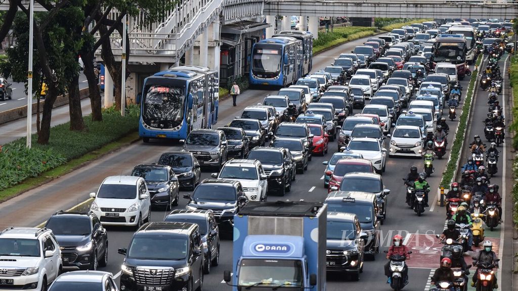 Bus Transjakarta melintas bersebelahan dengan kendaraan yang terjebak kemacetan di Jalan Jenderal Sudirman, Jakarta Pusat, Senin (13/12/2021). 
