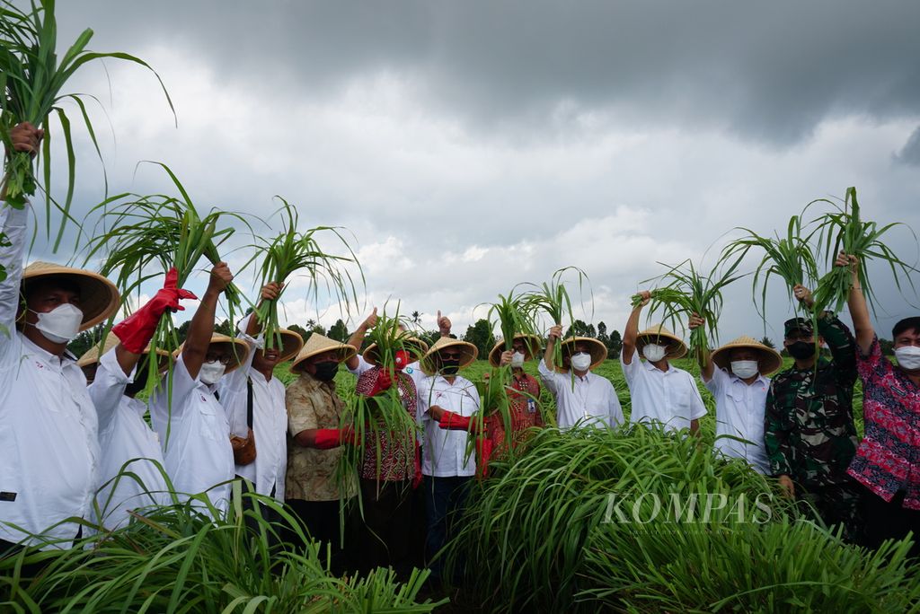 Pejabat tim percepatan akses keuangan daerah berfoto dengan tanaman serai wangi di Desa Tountimomor, Kakas Barat, Minahasa, Sulawesi Utara, Kamis (14/10/2021).