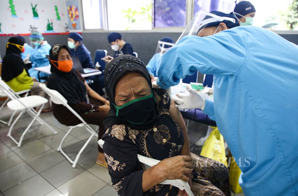 Petugas vaksinator menyuntikkan vaksin Covid-19 dosis pertama kepada warga lansia di Sekolah Cinta Kasih Tzu Chi, Cengkareng, Jakarta Barat, akhir Februari 2021. Warga lansia kini boleh mendapatkan vaksinasi penguat kedua. 