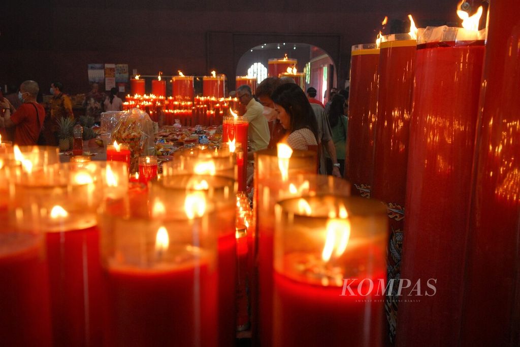 Umat bergantian menyalakan lilin dalam perayaan Imlek di Kelenteng Siau San Teng, Kota Jambi, Minggu (22/1/2023). Perayaan tahun baru kali ini menjadi yang terbesar setelah vakum dua tahun akibat pandemi Covid-19. 