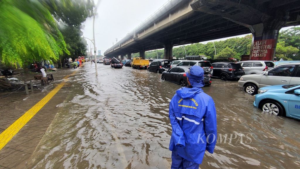Lalu lintas macet karena kendaraan terjebak banjir di perempatan Coca Cola, Cempaka Putih, Jakarta, Kamis (29/2/2024). Kota Jakarta dan sekitarnya diguyur hujan dengan intensitas sedang sejak pagi hari. Kondisi tersebut menyebabkan kemacetan di sejumlah kawasan. 