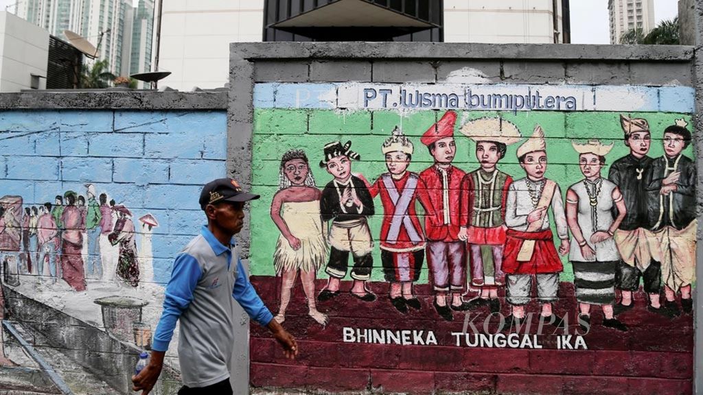 Warga melintas di depan mural bergambar keanekaragam suku dan budaya di salah satu sudut Jakarta, Kamis (20/9/2018). Keragaman budaya, suku dan agama harus menjadi perekat bagi kesatuan dan kemajuan bangsa Indonesia.