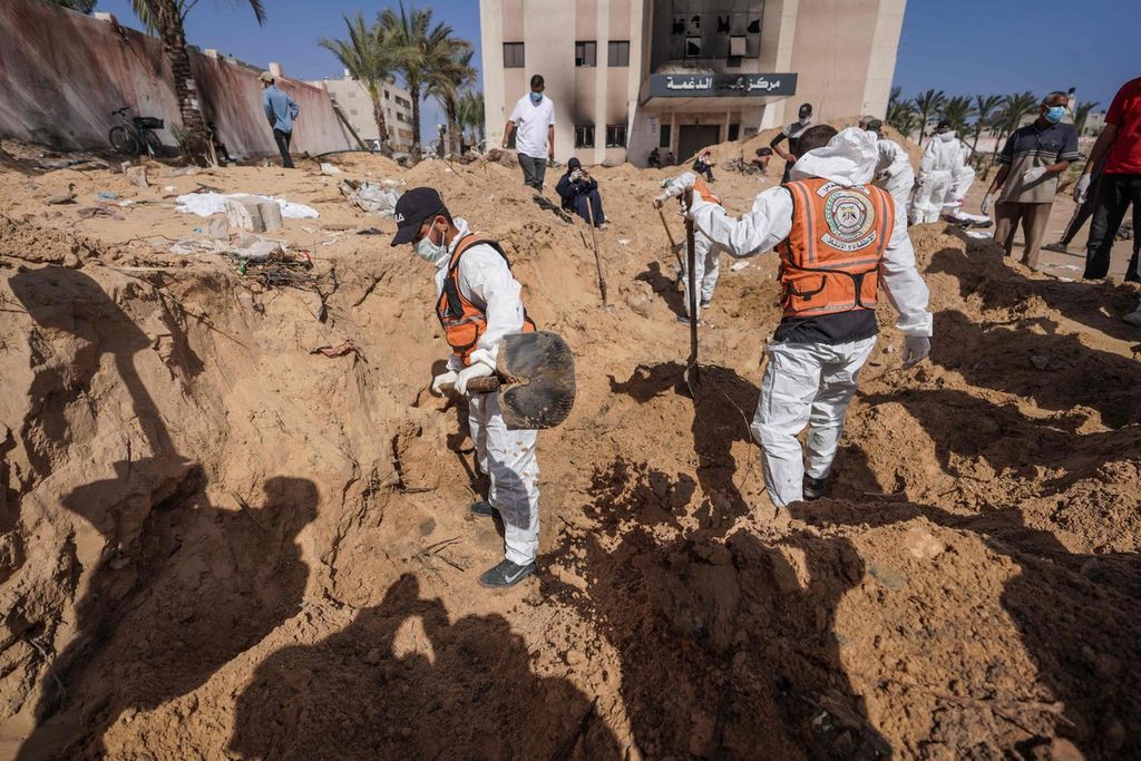 Petugas kesehatan Palestina menggali kuburan massal jenazah yang dikebumikan tentara Israel di kompleks Rumah Sakit Nasser di Khan Younis, Gaza selatan, Minggu (21/4/2024). 