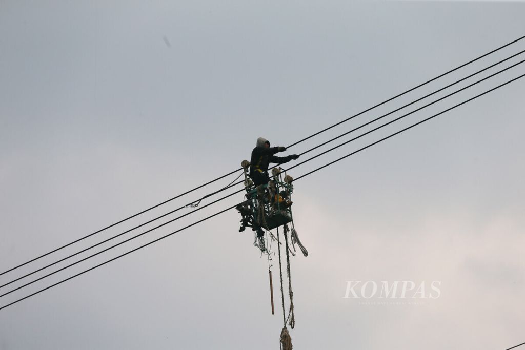 Petugas bergelantungan di saluran udara tegangan ekstratinggi (SUTET) untuk melakukan pemeliharaan jaringan di kawasan Setu, Tangerang Selatan, Banten, Jumat (12/7/2019).