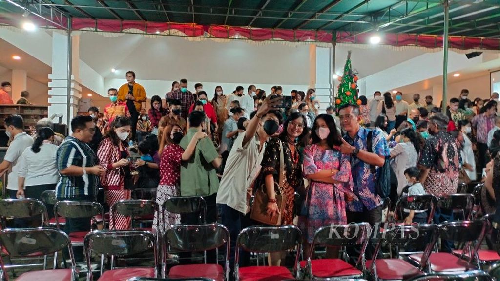 Sejumlah anggota jemaat merayakan momen kebersamaan dengan berswafoto bersama keluarga seusai mengikuti misa malam Natal di Gereja St Ignatius, Kota Magelang, Jawa Tengah, Sabtu (24/12/2022).