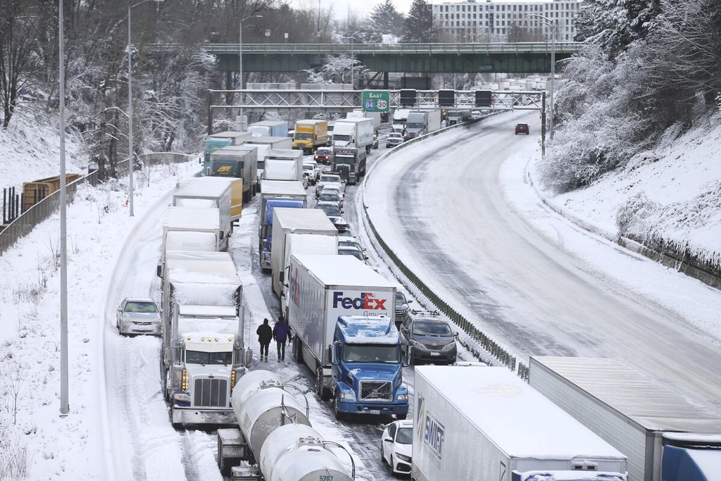 Kemacetan lalu-lintas kendaraan yang diakibatkan badai salju di Northeast Portland, Oregon, Amerika Serikat, Kamis (23/2/2023). Badai salju yang melanda sebagian wilayah Amerika tersebut melumpuhkan aktivitas dan layanan publik dalam beberapa hari ini. 