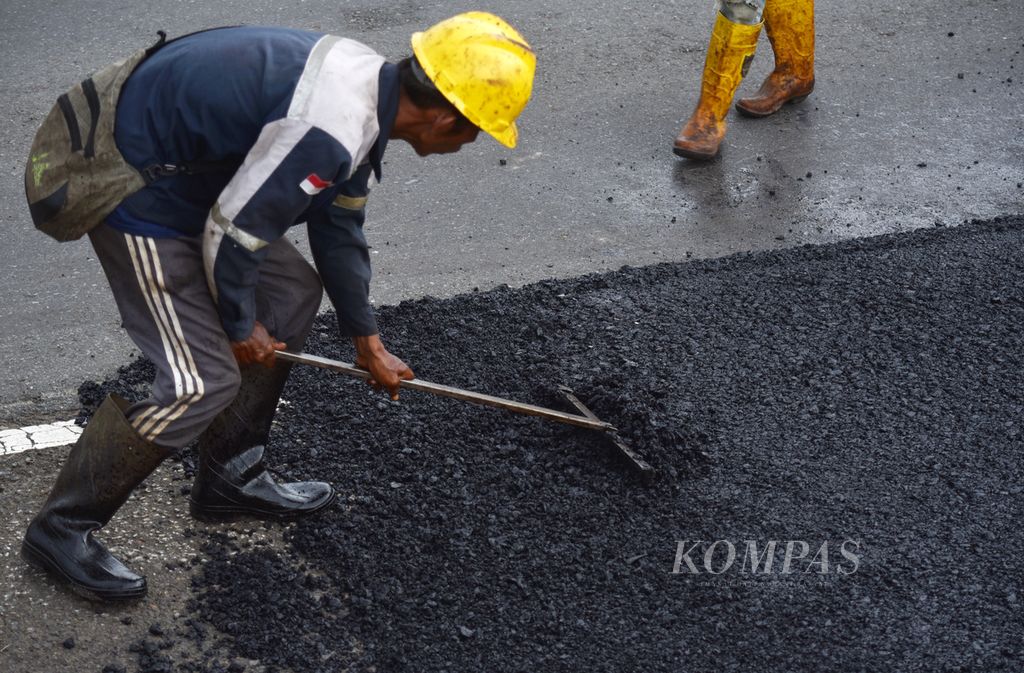 Petugas merapikan aspal sebelum diratakan menggunakan alat berat di salah satu lokasi proyek perbaikan jalan di Tol Kayu Agung-Palembang, Sumatera Selatan, Rabu (27/3/2024). 