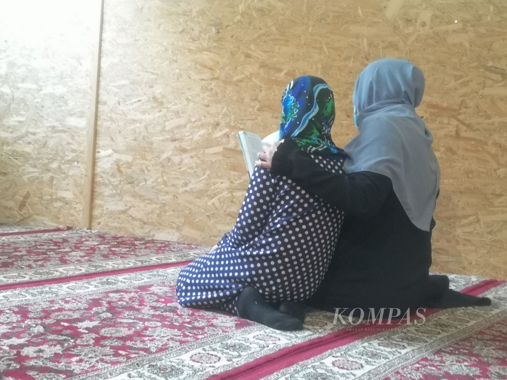 Seorang perempuan dan putrinya yang mengungsi dari Ukraina sedang membaca di dalam masjid Yayasan Sakinah, di Warsawa, Polandia, Selasa (7/6/2022). Yayasan Sakinah dengan sukarela menampung para pengungsi dari Ukraina yang keluar dari negaranya akibat serangan Rusia.