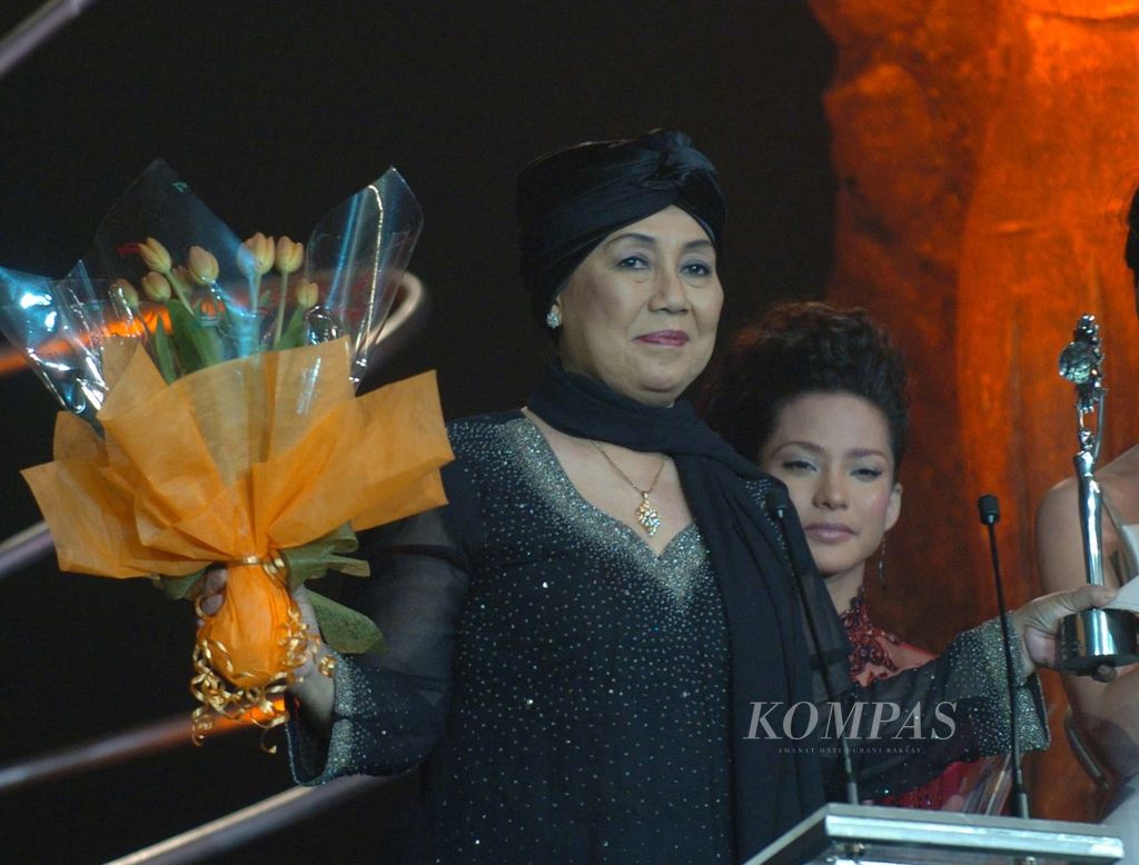 Nani Wijaya mengangkat piala dan bunga seusai menerima penghargaan Special Award Life Time Achievement dalam SCTV Award yang diselenggarakan dalam rangka ulang tahun ke-14 SCTV di JCC, Senayan, Jakarta, Jumat (27/8/2004). Kategori aktor dan aktris ngetop 2004 diraih Anjasmara dan Agnes Monica .