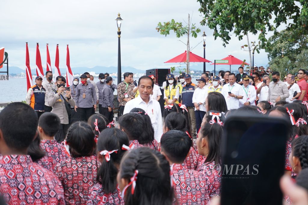 Presiden Joko Widodo menyapa anak-anak SD ketika meresmikan anjungan pantai Malalayang Beach Walk, Jumat (20/1/2023), di Manado, Sulawesi Utara. Proyek tersebut dibangun dengan anggaran APBN senilai Rp 65,48 miliar selama 2020-2022.