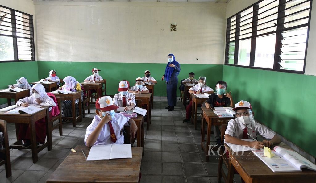 Guru memberikan materi pelajaran untuk siswa kelas 4 dalam hari pertama pembelajaran tatap muka terbatas di SDN 01 Semanan, Kalideres, Jakarta Barat, Senin (30/8/2021). 