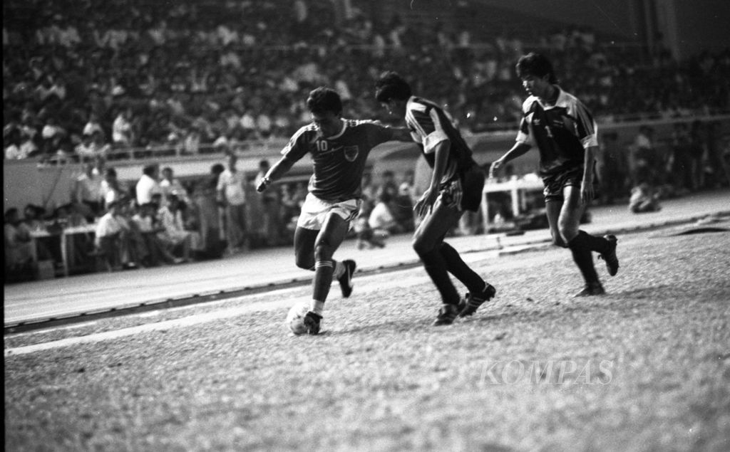 Penyerang Indonesia, Peri Sandria (kiri), menggiring bola untuk keluar dari kepungan pemain belakang Thailand pada laga final SEA Games 1991 melawan Thailand di Stadion Memorial Rizal, Manila, Filipina, Rabu 4 Desember 1991. 