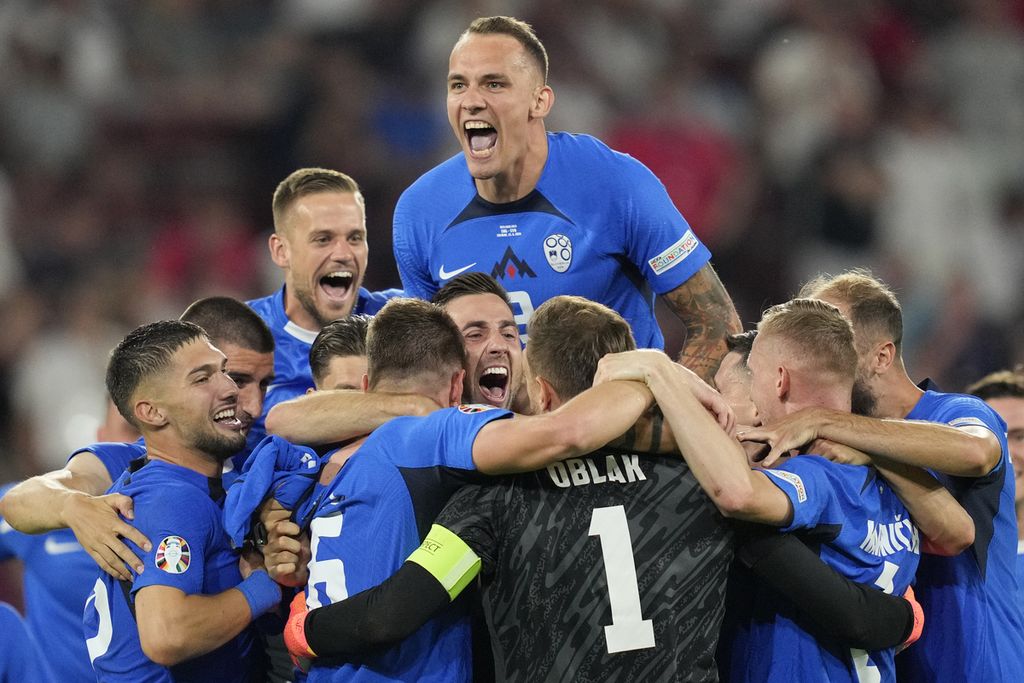 Para pemain Slovenia merayakan keberhasilan lolos ke babak 16 besar setelah menahan imbang Inggris, 0-0, pada laga pamungkas Grup C Piala Eropa 2024, Rabu (26/6/2024) dini hari WIB, di Stadion Koln, Jerman. 