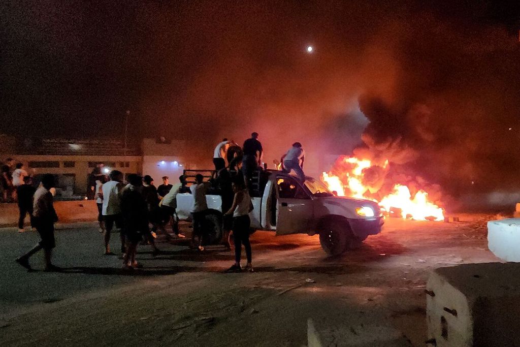 Warga Libya membakar ban-ban dalam unjuk rasa di Tripoli, Libya, Senin (28/8/2023), menyusul pertemuan antara Menteri Luar Negeri Libya Najla al-Mangoush dan Menlu Israel Eli Cohen. 