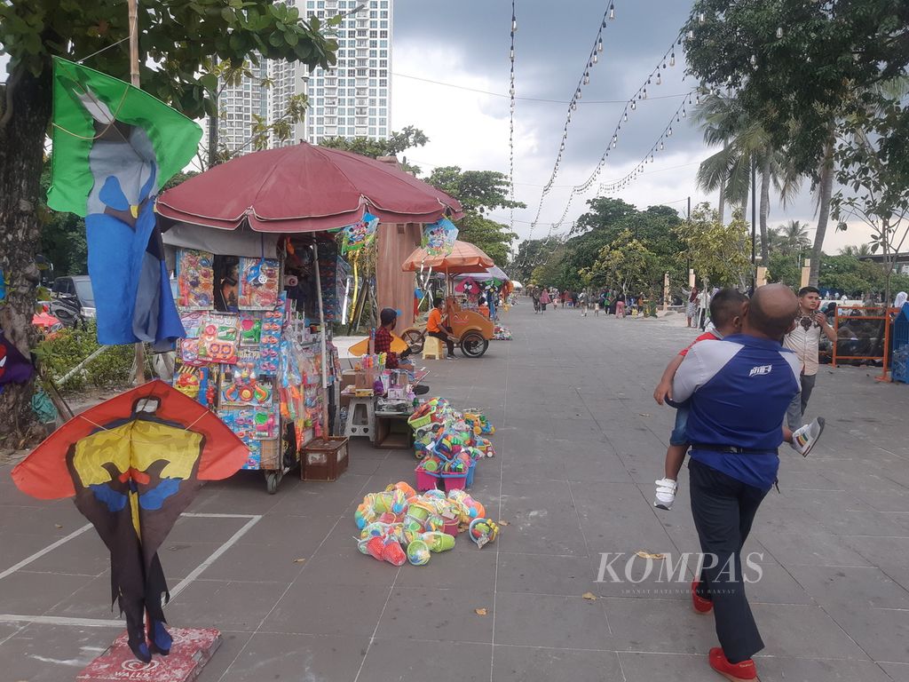Pengunjung melintas di dekat tempat pedagang mainan berjualan di Beach Poll, Ancol, pada Kamis (2/6/2022) sore.