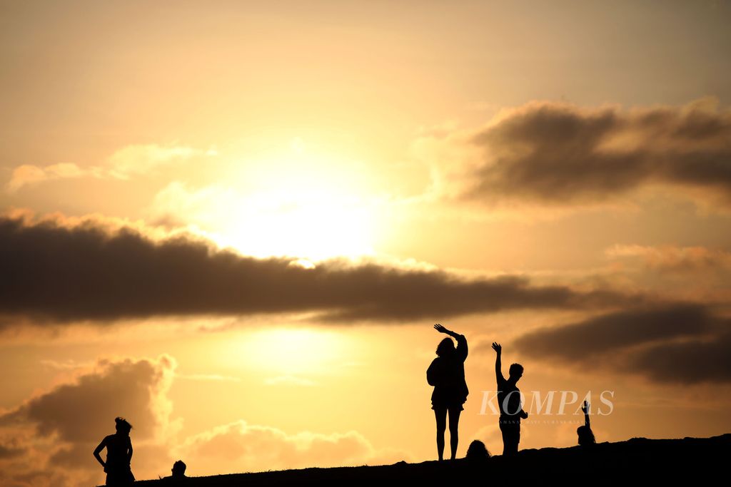 Wisatawan menikmati pesona matahari tenggelam dari Bukit Merese di Kuta, Kecamatan Pujut, Kabupaten Lombok Tengah, Nusa Tenggara Barat, Selasa (11/6/2024). 