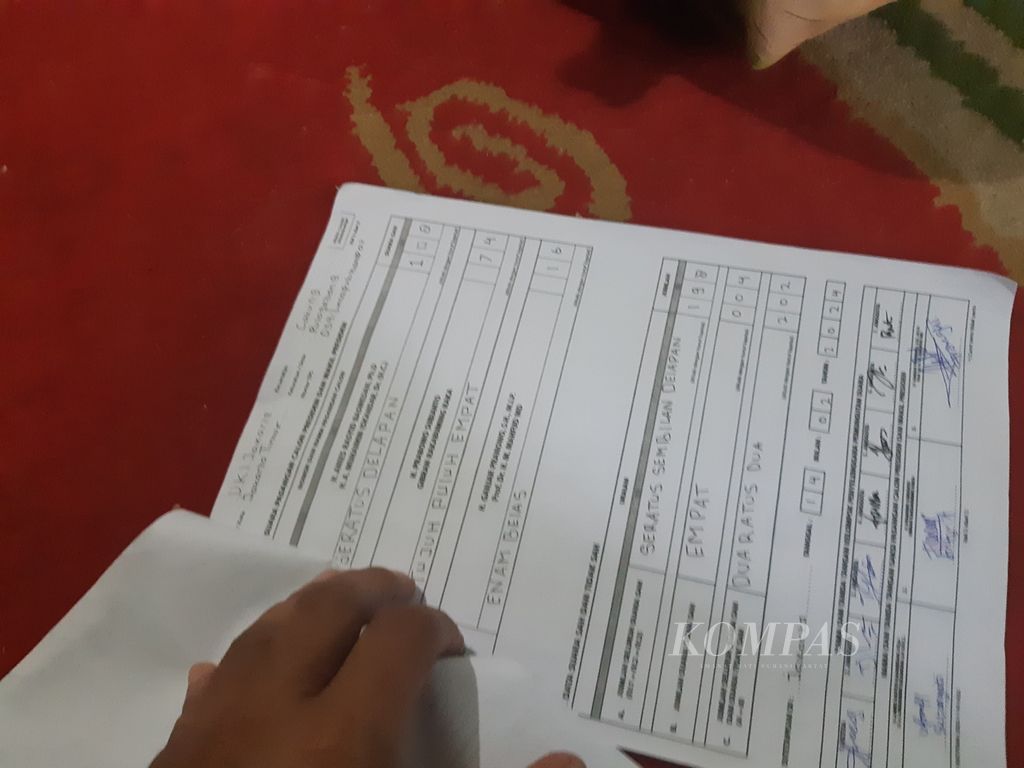 Marali, Ketua Kelompok Penyelenggara Pemungutan Suara TPS 54 Kelurahan Pulogebang, Kecamatan Cakung, Jakarta Timur, Kamis (15/2/2024), menunjukkan formulir rekapitulasi terkait hasil pemungutan suara pilpres.