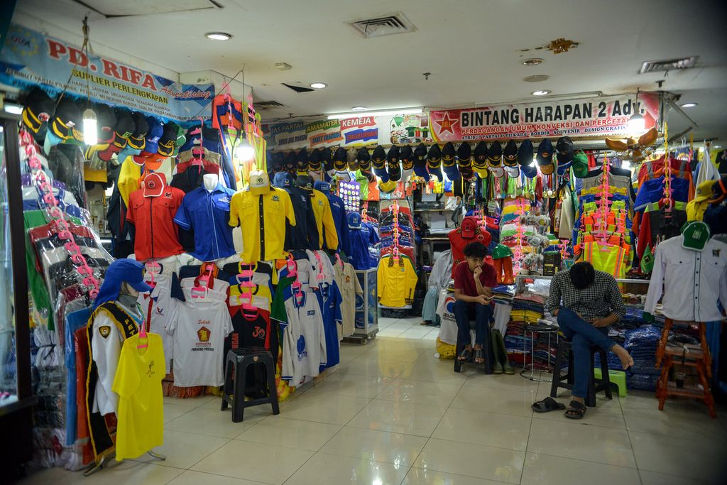 Pedagang menunggu pembeli di depan tokonya, di Pasar Senen Blok 3, Jakarta Pusat, 26 Mei 2023. Permintaan atribut partai mulai meningkat walaupun masa kampanye baru berlangsung pada November 2023. 