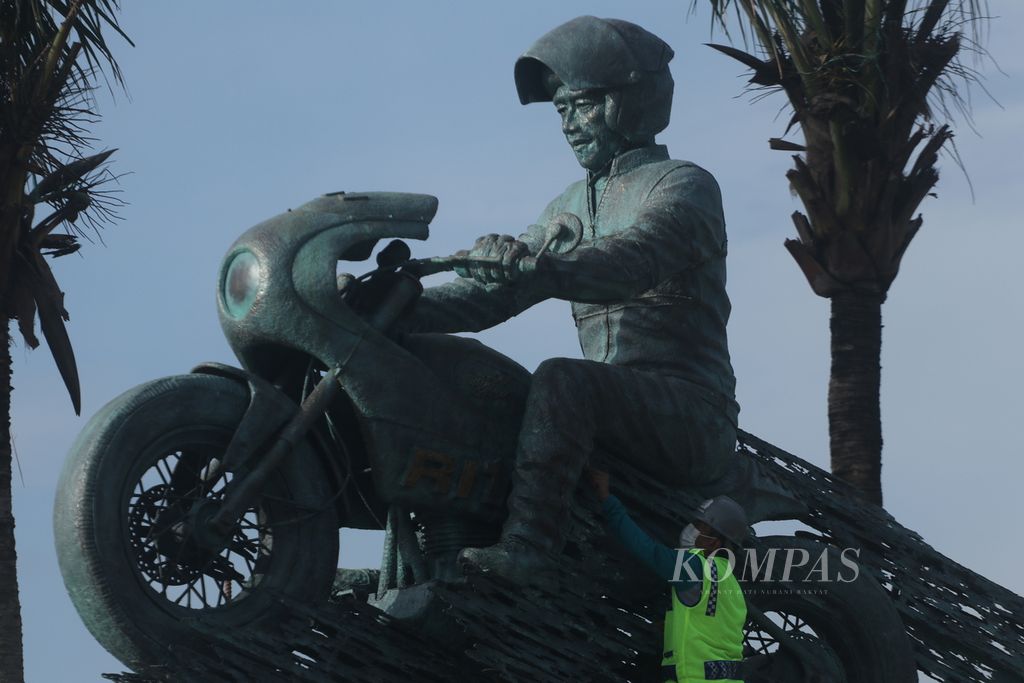 Patung Speed Jokowi karya senimam Nyoman Nuarta sudah dipasang di pintu gerbang hijau Sirkuit Mandalika, Lombok Tengah, Nusa Tenggara Barat, Minggu (13/3/2022). Patung seberat 3 ton dengan lapisan luar tembaga dan kuningan yang dioksidasi ini melambangkan kecepatan dan akselerasi yang dilakukan oleh Presiden Joko Widodo. Patung kembali ditutup dengan kain hingga peresmian saat balapan MotoGP seri Indonesia, 18-20 Maret.
