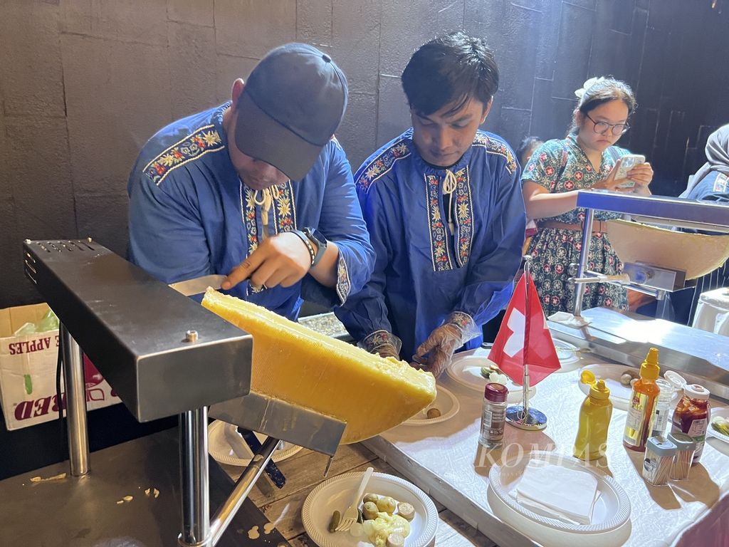 Dua orang petugas tengah mempersiapkan hidangan tradisional Swiss, <i>raclette</i>, yang berbahan dasar keju di acara penutupan Pekan Frankofoni 2024 di IFI Jakarta, Sabtu (23/3/2024). 