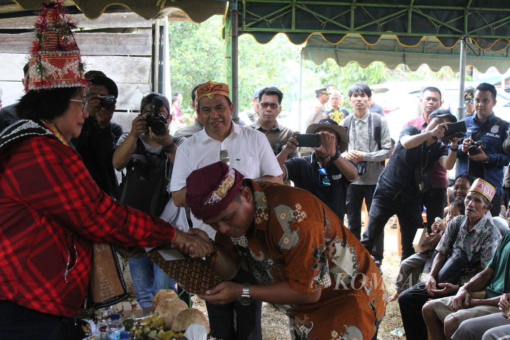 Kepala Desa Kinipan Willem Hengki memberikan dokumen sikap masyarakat adat Kinipan soal hutan adat dan nasib mereka kepada Menteri Lingkungan Hidup dan Kehutanan RI Siti Nurbaya, di Desa Kinipan, Kabupaten Lamandau, Kalimantan Tengah, Sabtu (7/9/2024).