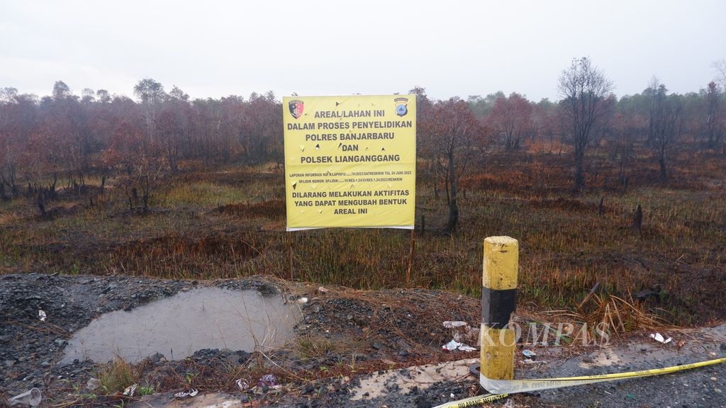 Spanduk informasi dan peringatan dari kepolisian masih terpasang di lahan gambut yang terbakar di Kecamatan Liang Anggang, Kota Banjarbaru, Kalimantan Selatan, Rabu (5/7/2023). Kebakaran lahan tersebut pada akhir Juni 2023 menimbulkan kabut asap.