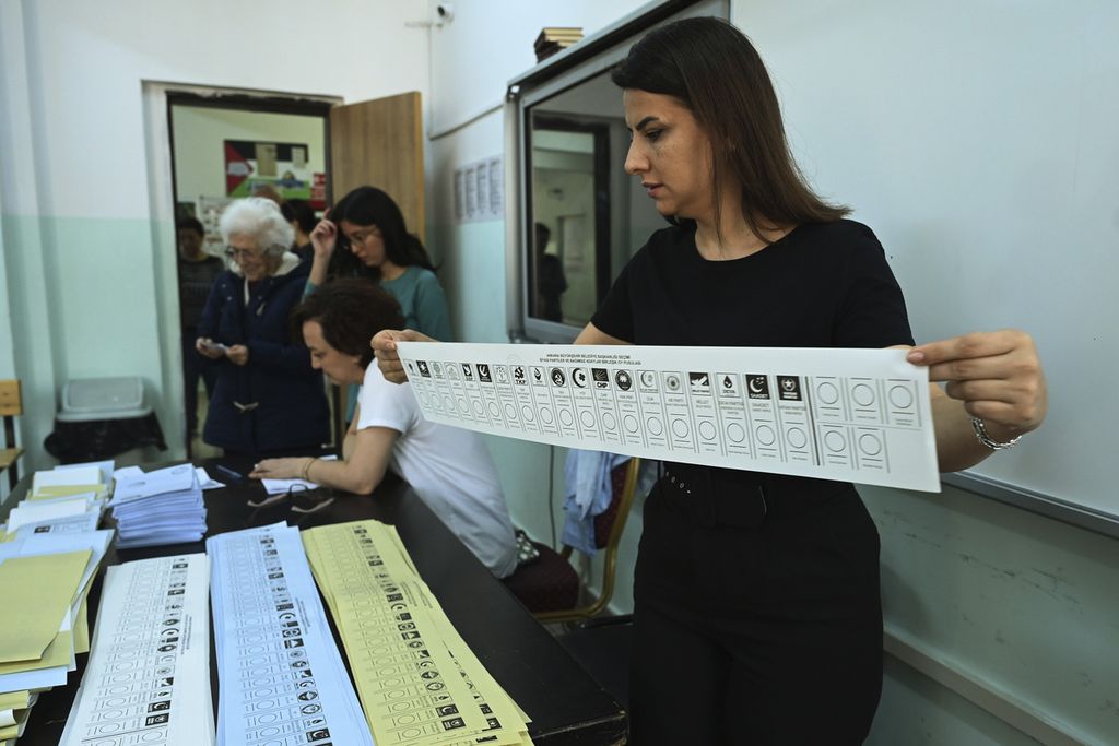 Salah satu petugas pemilu membantu proses pemungutan suara di tempat pemungutan suara di Ankara, 31 Maret 2024.