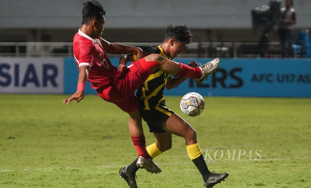 Striker Indonesia, Muhammad Nabil Asyura (kiri), berebut bola dengan bek Malaysia, Muhammad Danish Darus (kanan), dalam laga kualifikasi Piala Asia U-17 2023 di Stadion Pakansari, Bogor, Jawa Barat, Minggu (9/10/2022). Indonesia takluk 1-5 pada laga itu. 