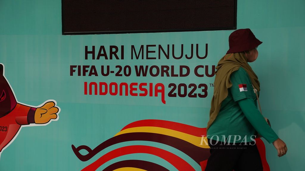 Warga melintasi hitungan mundur menuju Piala Dunia U-20 yang tidak menyala kembali di halaman kantor PSSI di GBK Arena, Jakarta, Kamis (30/3/2023). FIFA membatalkan status Indonesia sebagai tuan rumah Piala Dunia U-20 2023. 