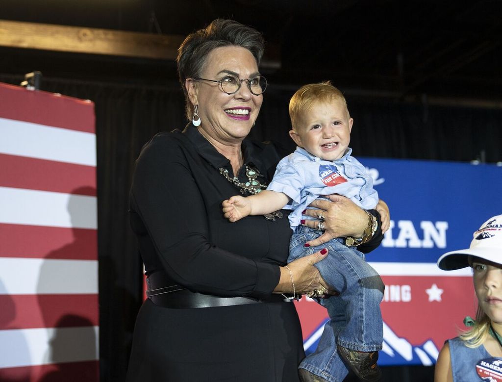  Kandidat anggota Kongres AS asal Partai Republik, Harriet Hageman, tersenyum sambil menggendong seorang bocah pada acara malam pemilihan pendahuluan Partai Republik di Cheyenne, Negara Bagian Wyoming, AS, Selasa (16/8/2022). 