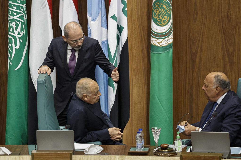 Menteri Luar Negeri Yordania Ayman Safadi (berdiri) berbincang dengan Menlu Mesir Sameh Shoukry (kanan, duduk) dan Sekjen Liga Arab Ahmed Aboul Gheit (duduk tengah) berbincang di sela pertemuan menlu negara anggota Liga Arab di Kairo, Mesir, Minggu (7/5/2023). Yordania dan Mesir bersama tiga negara lainnya akan menjadi bagian dari komite kecil yang akan menyusun peta jalan damai Suriah.(Photo by Khaled DESOUKI / AFP)