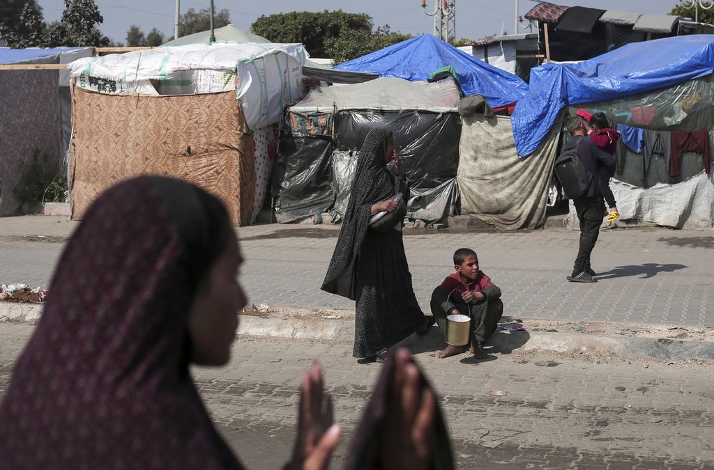 Warga Palestina yang mengungsi berkumpul di kamp Rafah untuk mendapatkan pembagian makanan, 28 Februari 2024. 