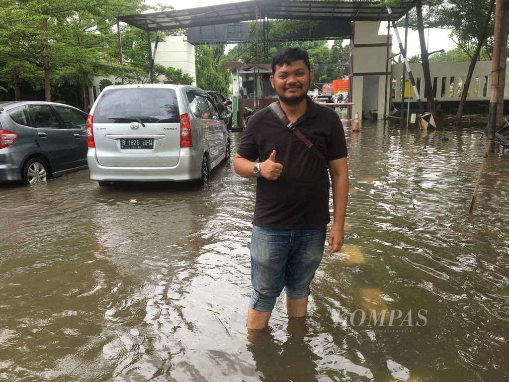 Akbar (27), warga Perumahan Metro Permata 2 Karang Tengah, tetap menggunakan hak pilih meski akses menuju TPS banjir pada Rabu (14/2/2024).
