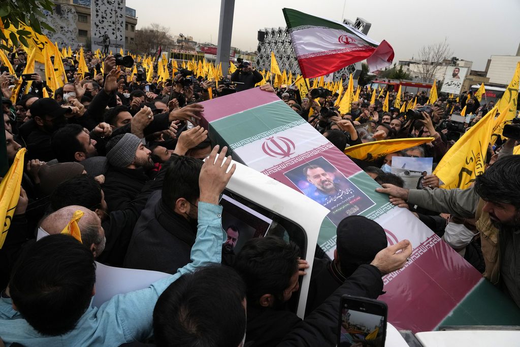  Warga Iran yang berkabung membawa peti mati berbalut bendera Iran dan foto Seyed Razi Mousavi, jenderal Garda Revolusi Iran, yang tewas dalam dugaan serangan udara Israel di Suriah, pada upacara pemakamannya di Teheran, Iran, 1 Desember 2017. 