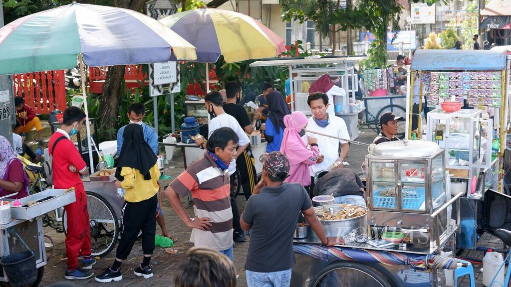 Pengunjung menyerbu penjual makanan dan minuman setelah berolahraga di kawasan wisata siring Menara Pandang, Sungai Martapura, Kota Banjarmasin, Kalimantan Selatan, Minggu (28/6/2020). Meskipun pemerintah belum membuka kawasan tersebut secara resmi, pengunjungnya sudah kembali ramai.