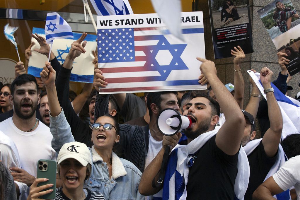 Pendukung Israel berunjuk rasa di depan Kedutaan Besar Israel di San Fransisco, Amerika Serikat, Minggu (8/10/2023), sambil melambaikan poster pada rombongan pendukung Palestina. 