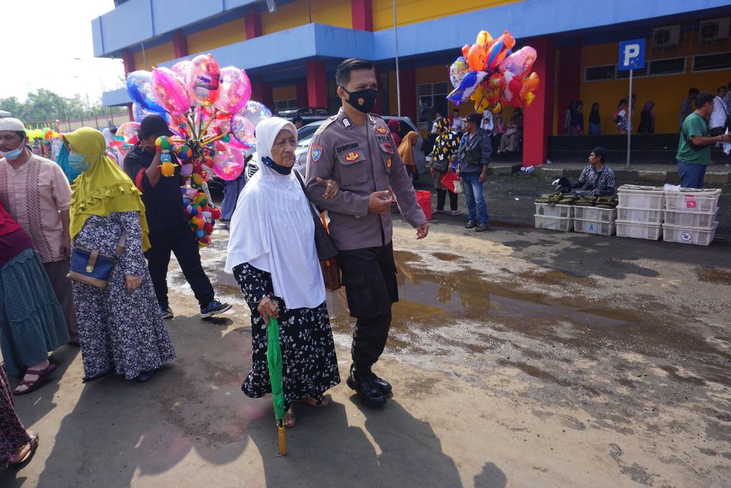 Polisi menuntun seorang lansia dalam pemberangkatan calon jemaah haji di GOR Satria Purwokerto, Banyumas, Jawa Tengah, Rabu (22/6/2022).