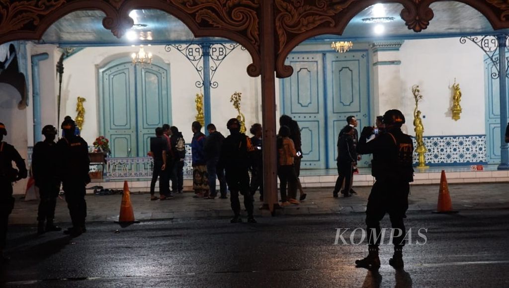 Aparat kepolisian berjaga di depan area Kori Kamandungan Keraton Surakarta, Kota Surakarta, Jawa Tengah, Jumat (23/12/2022) malam. Mereka melakukan pengamanan pascaberedarnya kabar gesekan di dalam lingkup keraton.