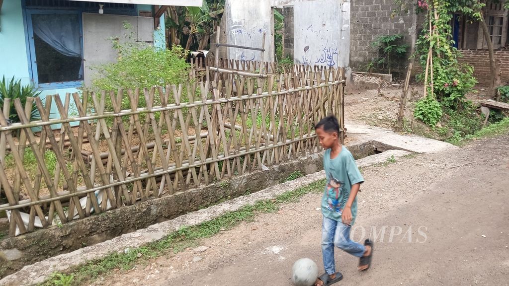 Seorang anak asuh sedang mengiring bola di depan halaman rumah warga yang telah diubah menjadi kebun, Sabtu (10/8/2024), di Perumnas 2, Parung Panjang, Kabupaten Bogor, Jawa Barat.